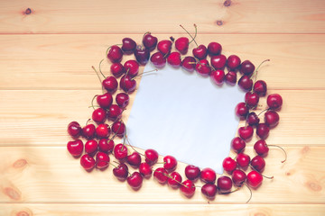 White card for notes with cherries on wooden background