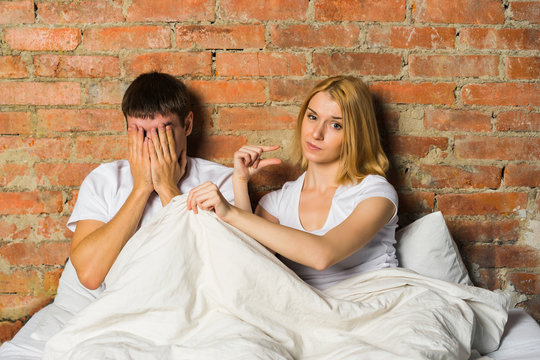 Small size: couple lying in bed, woman showing by fingers size of men's genital.