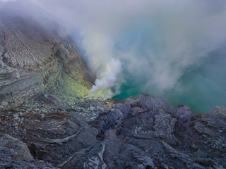 Aerial view from drone to Kawah Ijen volcano crater with sulfur fume. Ijen crater the famous tourist attraction near Banyuwangi, East Java, Indonesia