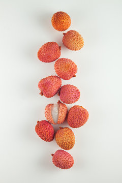 ripe, vermilion exotic lichees decorated on a white plate kitchen table background with napkin