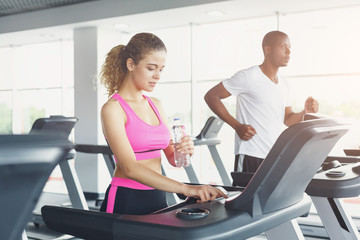 Fototapeta na wymiar Man and woman, couple in gym on treadmills