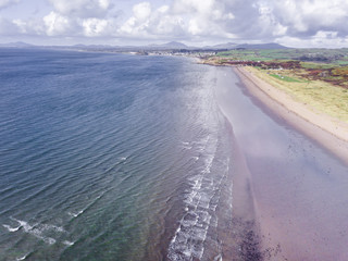 Fototapeta na wymiar Beautiful, Picturesque Aerial View of the Coastline at Porthmadog Beach in Wales, UK. Taken 400 feet in the air, down the beach towards Criccieth.