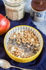 Porridge bowl. Oatmeal with apple and chia. Breakfast and coffee. Yellow bowl and cup of coffee.