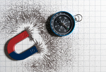 Red and blue horseshoe magnet or physics magnetic and compass with iron powder magnetic field on...