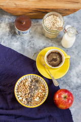 Porridge bowl. Oatmeal with apple and chia. Breakfast and coffee. Yellow bowl and cup of coffee.