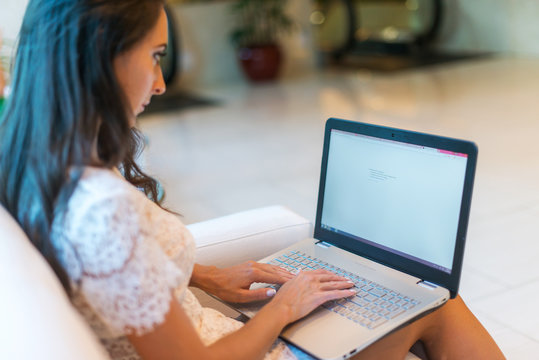 Female hands on keyboard with opened web page in browser at screen. Cropped image of woman surfing the internet her laptop.