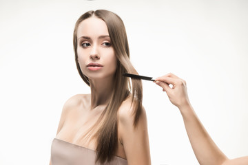 Obraz premium Beautiful young long-haired girl brushed by the stylist.