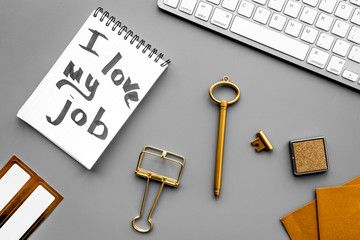 Find dream job. Handwritten motto I love my job in notebook near stationery on grey background top view