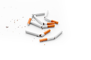 Smoking. Half-smoked cigarettes with ash on white background top view copyspace