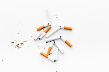 Smoking. Half-smoked cigarettes with ash on white background top view