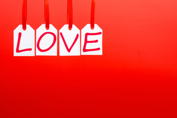 Love word is written in the white tags on the red background.