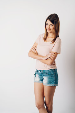 Woman in denim shorts standing with arms folded