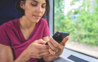 Woman texting on her phone during her trip in train