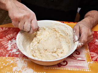 Mens hands knead dough