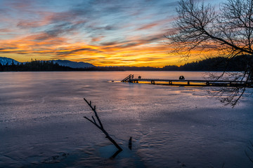Naklejka premium Chillen im Abendrot auf dem Steg des Kirchsee in Oberbayern