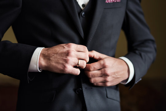 businessman wears a jacket,male hands closeup,groom getting ready in the morning before wedding ceremony