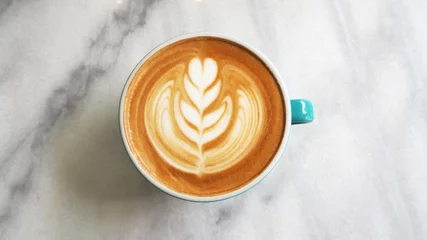 Foto op Plexiglas close-up warme koffie latte art cup op tafel. © NaMong Productions