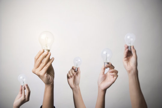 hand holding light bulb, concept teamwork ideas with innovation and creativity.