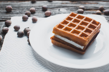 Waffle on a wooden background on a white napkin