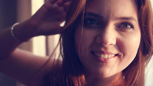 A happy young girl turns with a cameo, the rays of the sun fall into the lens, create the effect of the lens. HD, 1920x1080, slow motion