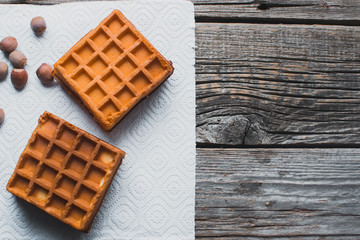Waffle on a wooden background on a white napkin