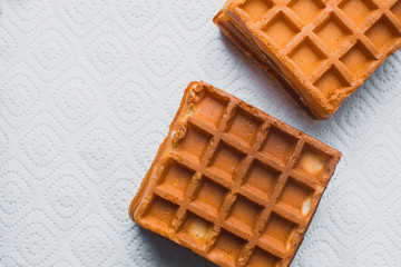 Waffle on a wooden background on a white napkin