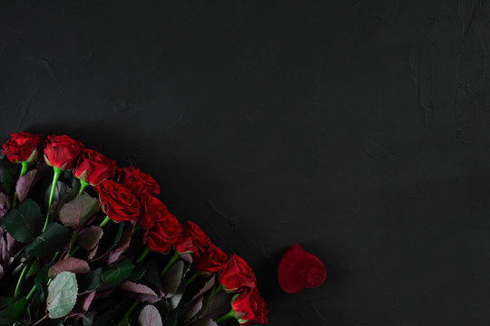 Fototapeta A bouquet of red roses and a box of ring. View top