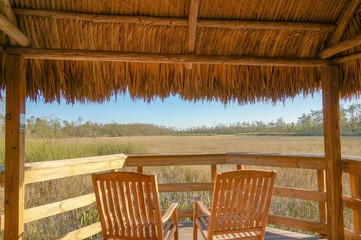tiki hut and chairs in swamp