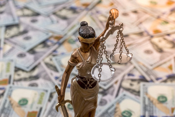 Themis statue standing against the background of dollars