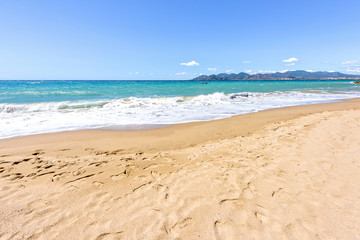 Obraz na płótnie Canvas Daylight sunny view to blue sea and sand with traces