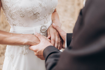newlywed couple, groom and bride holding each other's hands with rings - 187368134