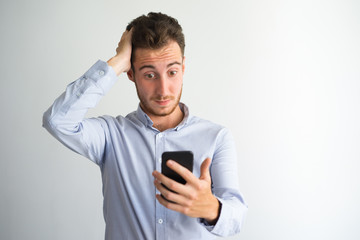 Confused businessman reading message on phone