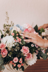 hand of the bride with a wedding ring on a bouquet of flowers