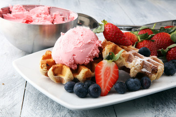 Plate of belgian waffles with strawberry ice cream, and fresh strawberries