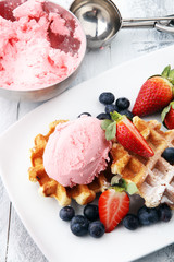 Plate of belgian waffles with strawberry ice cream, and fresh strawberries