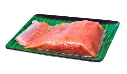 Piece of smoked salted salmon on green plate