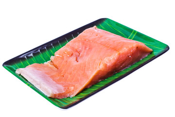 Piece of smoked salted salmon on green plate