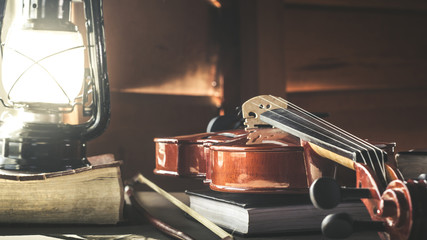 Violin with old bible book on wooden table