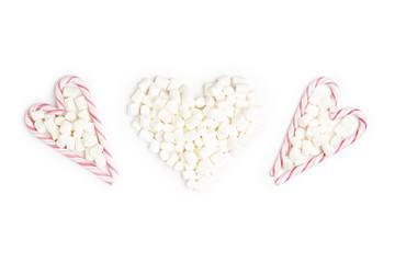 Striped Lollipops and Marshmallow in the shape of three heart Top view White Background Valentine's Day