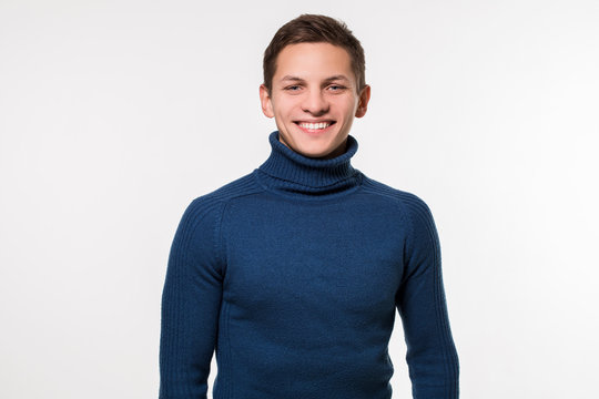 Studio Shot Of Young Man Wearing Blue Turtleneck Sweater Against