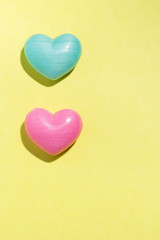 Couple of heart shapes over yellow table. Valentines day symbol for background use. Love, romance, and passion.