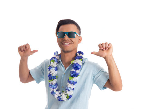 Playful man points to himself with thumbs. Young black man wears sunglasses and flower necklace..