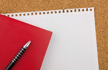 Empty square sheet of white paper wrested from notepad for your text. There are red notebook, black...
