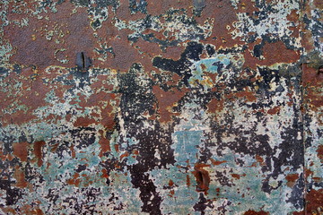Corroded rusty weathered and worn brown blue and black painted metallic surface.