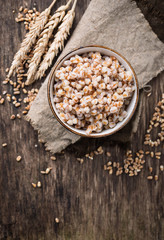 Bowl of barley porridge on wooden background