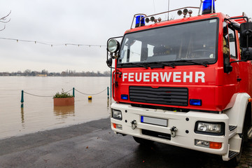 Fire department car on the flooded shore of a river