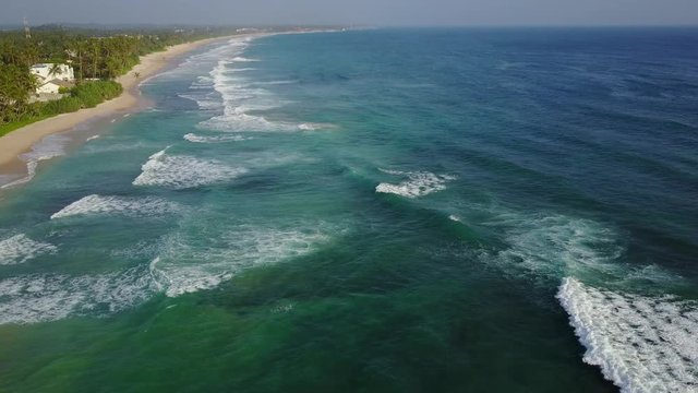 Top view on ocean with waves. Surf spot. Drone fly over water. Green water. Wild ocean. No colour correction. D Log. Drone video.