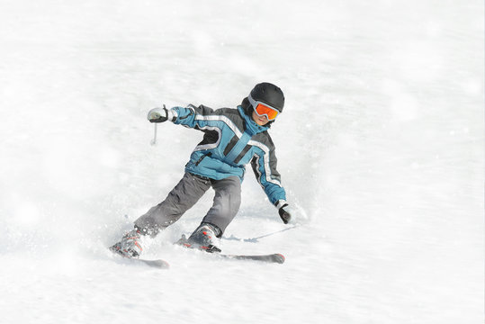 The boy in a blue jacket on skis in mountains