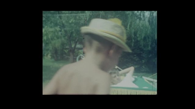 1966 Little boy tips older brother out of hammock