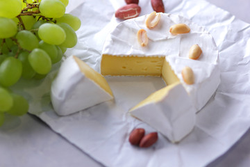 Cheese, camembert on white background, cheese with green grapes, peanuts, minimalism, healthy food, French breakfast, white mold